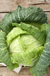 Photo of Fresh ripe Savoy cabbage on wooden table, top view