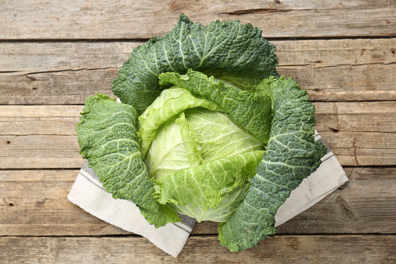 Photo of Fresh ripe Savoy cabbage on wooden table, top view