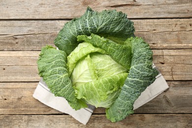 Photo of Fresh ripe Savoy cabbage on wooden table, top view