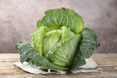 Photo of Fresh ripe Savoy cabbage on wooden table, closeup