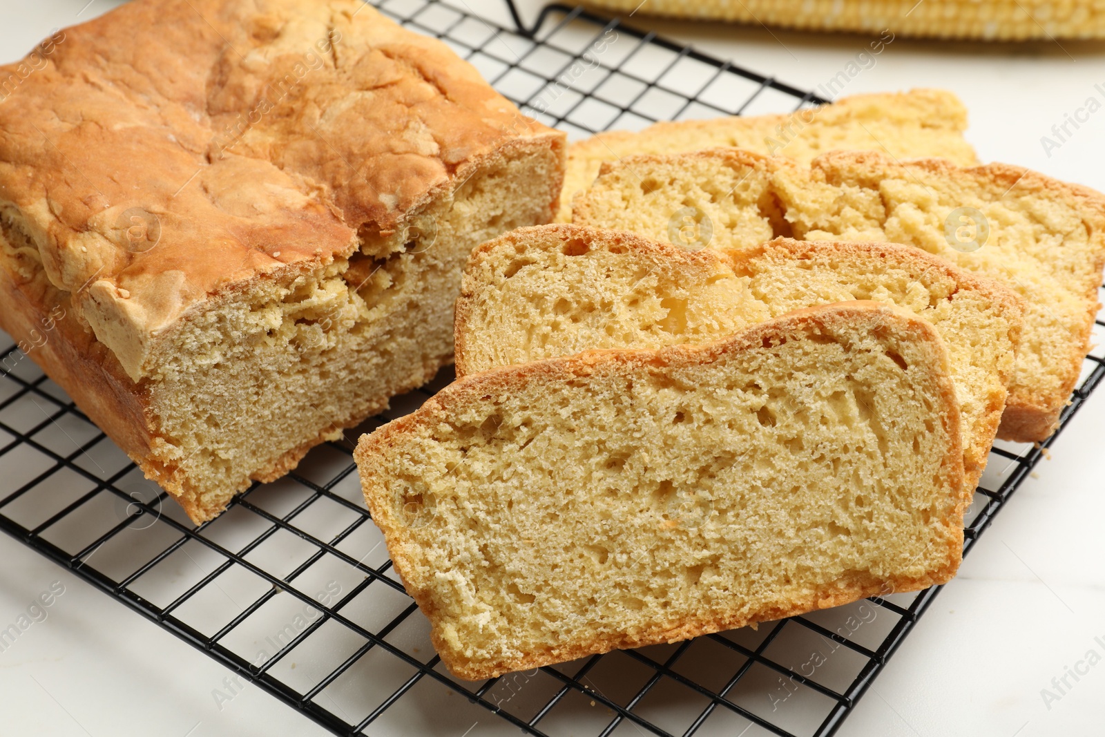 Freshly baked cut cornbread on white table, closeup Photo of Freshly baked cut cornbread on white table, closeup