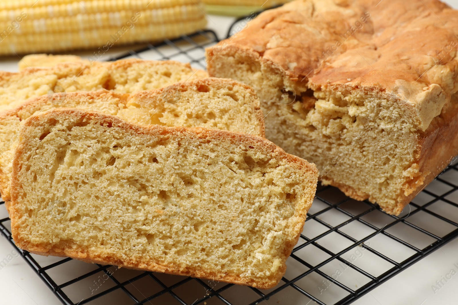 Freshly baked cut cornbread on white table, closeup Photo of Freshly baked cut cornbread on white table, closeup