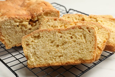 Photo of Freshly baked cut cornbread on white table, closeup
