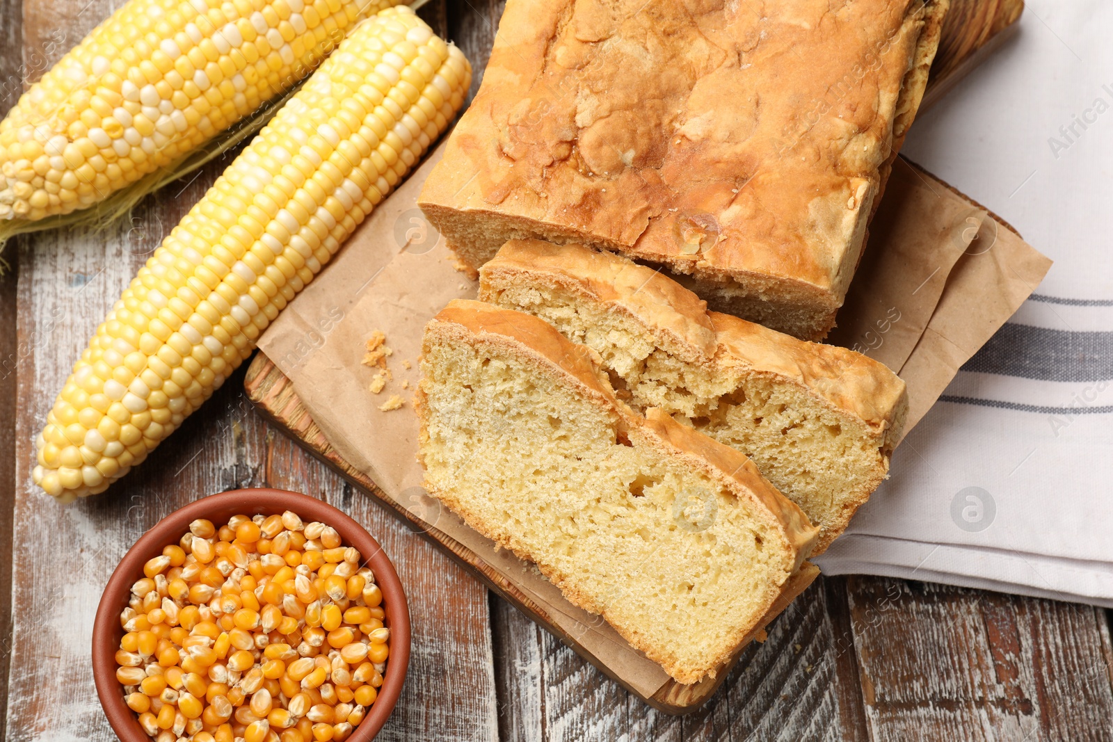 Freshly baked cut cornbread, cobs and seeds on wooden table, flat lay Photo of Freshly baked cut cornbread, cobs and seeds on wooden table, flat lay