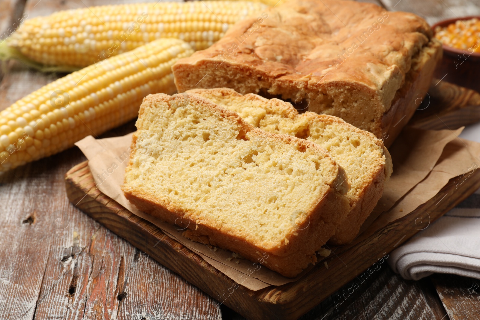 Freshly baked cut cornbread and cobs on wooden table, closeup Photo of Freshly baked cut cornbread and cobs on wooden table, closeup