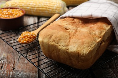 Photo of Freshly baked cornbread and seeds on wooden table, closeup