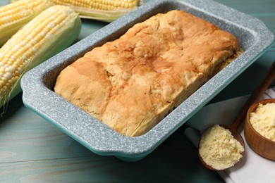 Photo of Freshly baked cornbread, flour and cobs on light blue wooden table, closeup