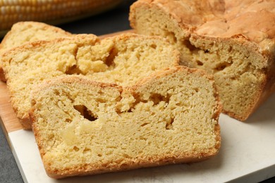 Photo of Pieces of freshly baked cornbread on table, closeup