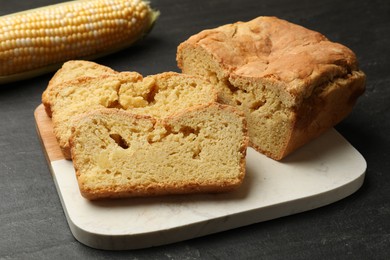 Photo of Freshly baked cornbread and cob on black table, closeup