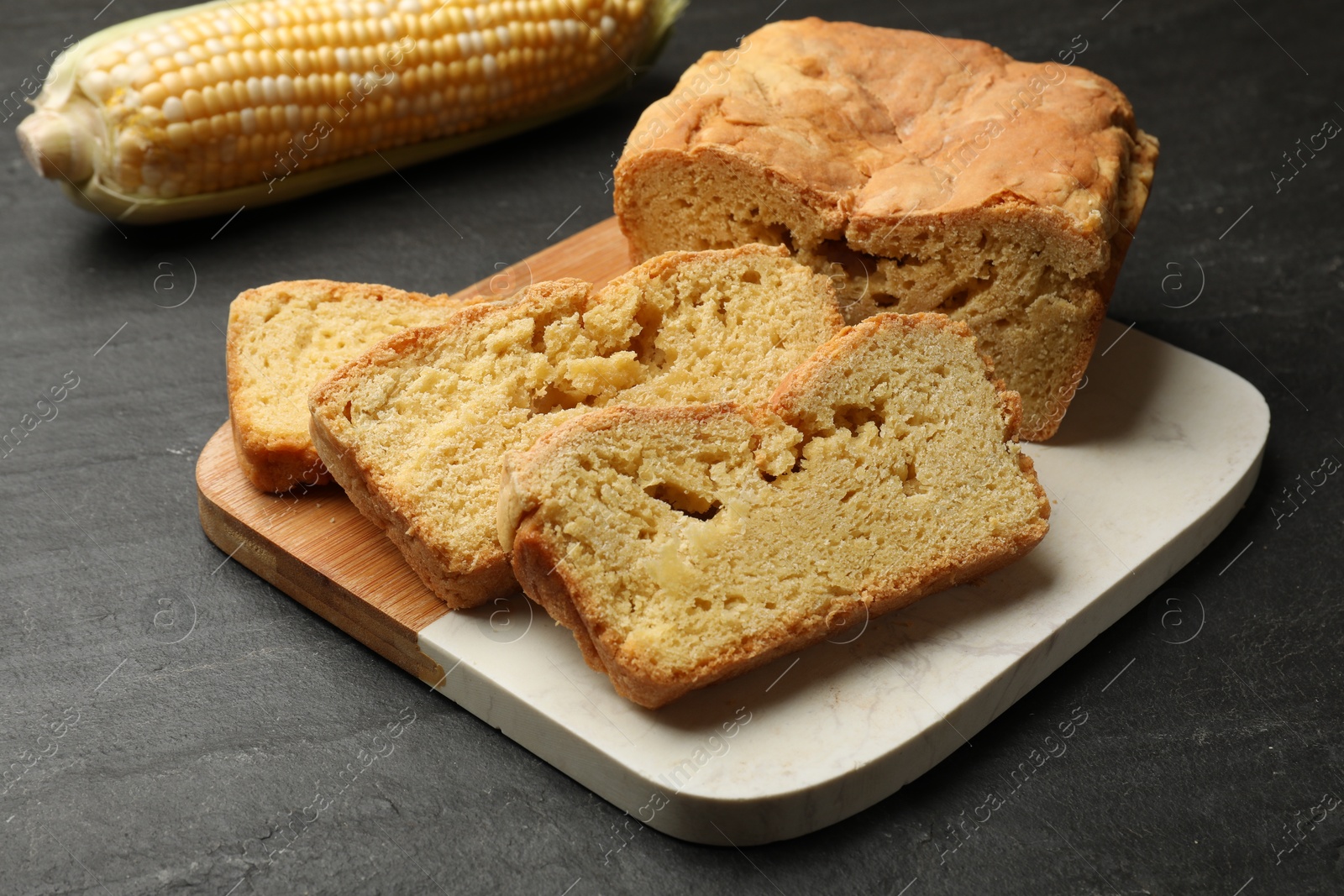 Photo of Freshly baked cornbread and cob on black table, closeup