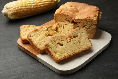 Photo of Freshly baked cornbread and cob on black table, closeup