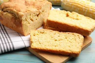 Photo of Freshly baked cornbread and cob on light blue wooden table, closeup