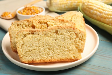 Photo of Freshly baked cornbread, cobs and seeds on light blue wooden table, closeup