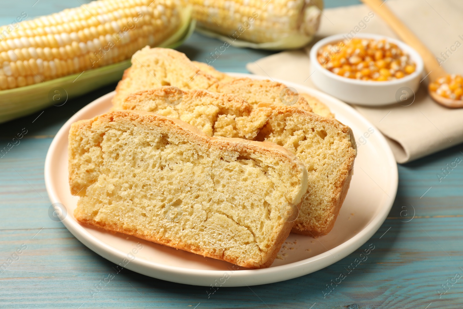 Freshly baked cornbread, cobs and seeds on light blue wooden table, closeup Photo of Freshly baked cornbread, cobs and seeds on light blue wooden table, closeup