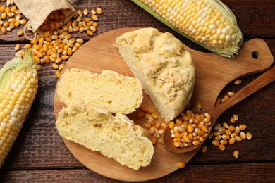 Photo of Freshly baked cornbread, cobs and seeds on wooden table, flat lay