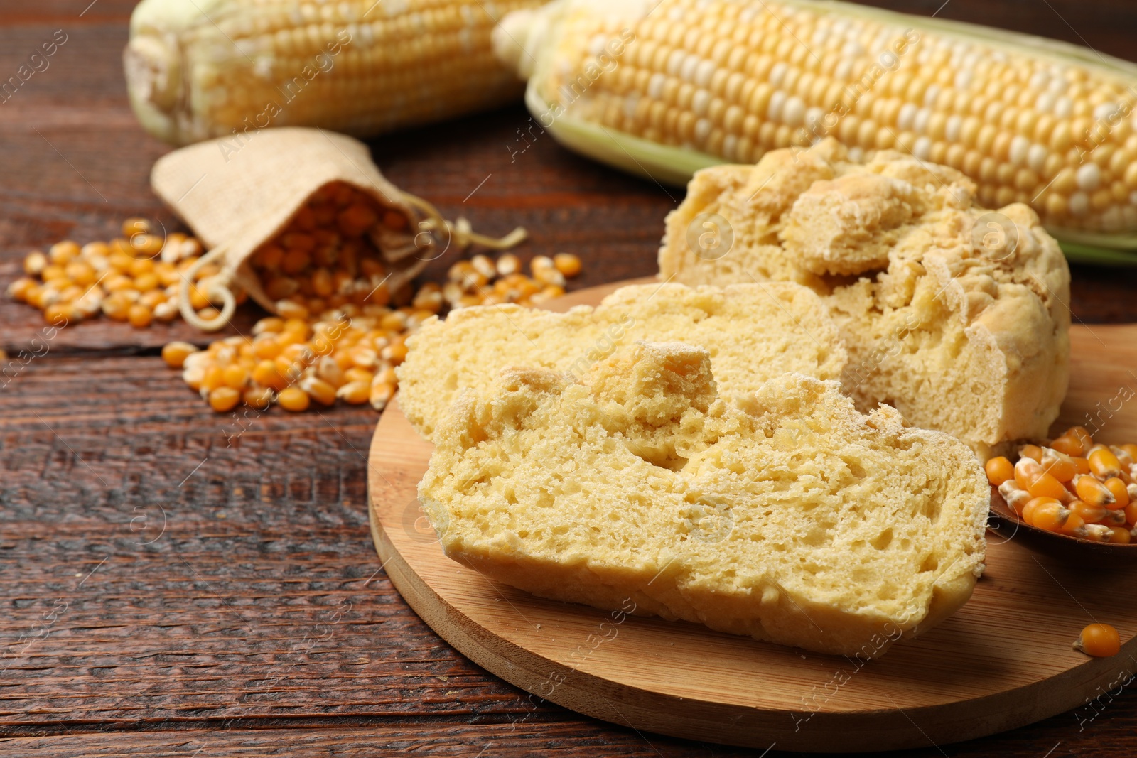 Photo of Freshly baked cornbread, cobs and seeds on wooden table, closeup. Space for text