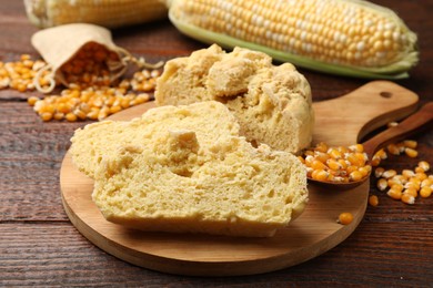 Photo of Freshly baked cornbread, cobs and seeds on wooden table, closeup