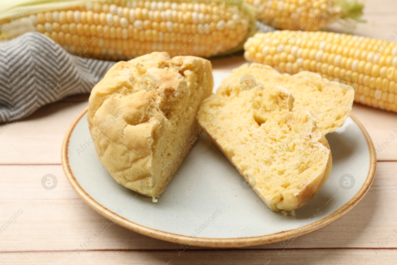 Photo of Freshly baked cornbread and cobs on wooden table, closeup