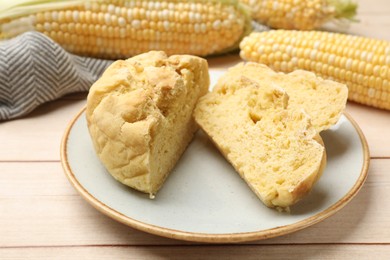 Photo of Freshly baked cornbread and cobs on wooden table, closeup