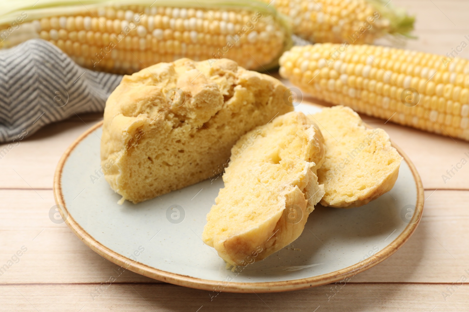 Freshly baked cornbread and cobs on wooden table, closeup Photo of Freshly baked cornbread and cobs on wooden table, closeup