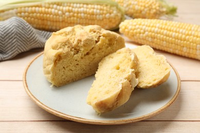 Photo of Freshly baked cornbread and cobs on wooden table, closeup