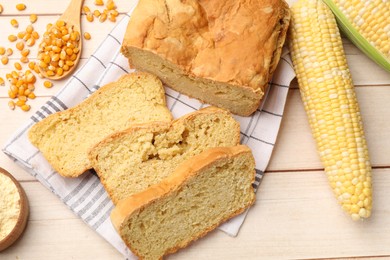Photo of Freshly baked cornbread, cobs and seeds on wooden table, flat lay