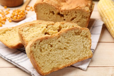 Photo of Freshly baked cornbread, cob and seeds on wooden table, closeup