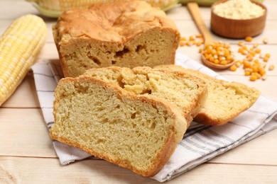 Photo of Freshly baked cornbread, cobs and seeds on wooden table, closeup
