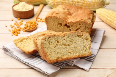 Photo of Freshly baked cornbread, cobs and seeds on wooden table, closeup