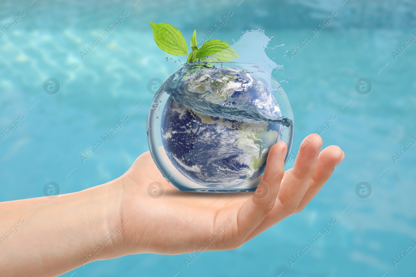 Image of Save water concept. Earth and plant branch inside aquarium bowl with splashing water in human hand against sea surface