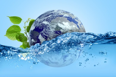 Image of Save water concept. Earth and plant branch falling into water against pale blue background