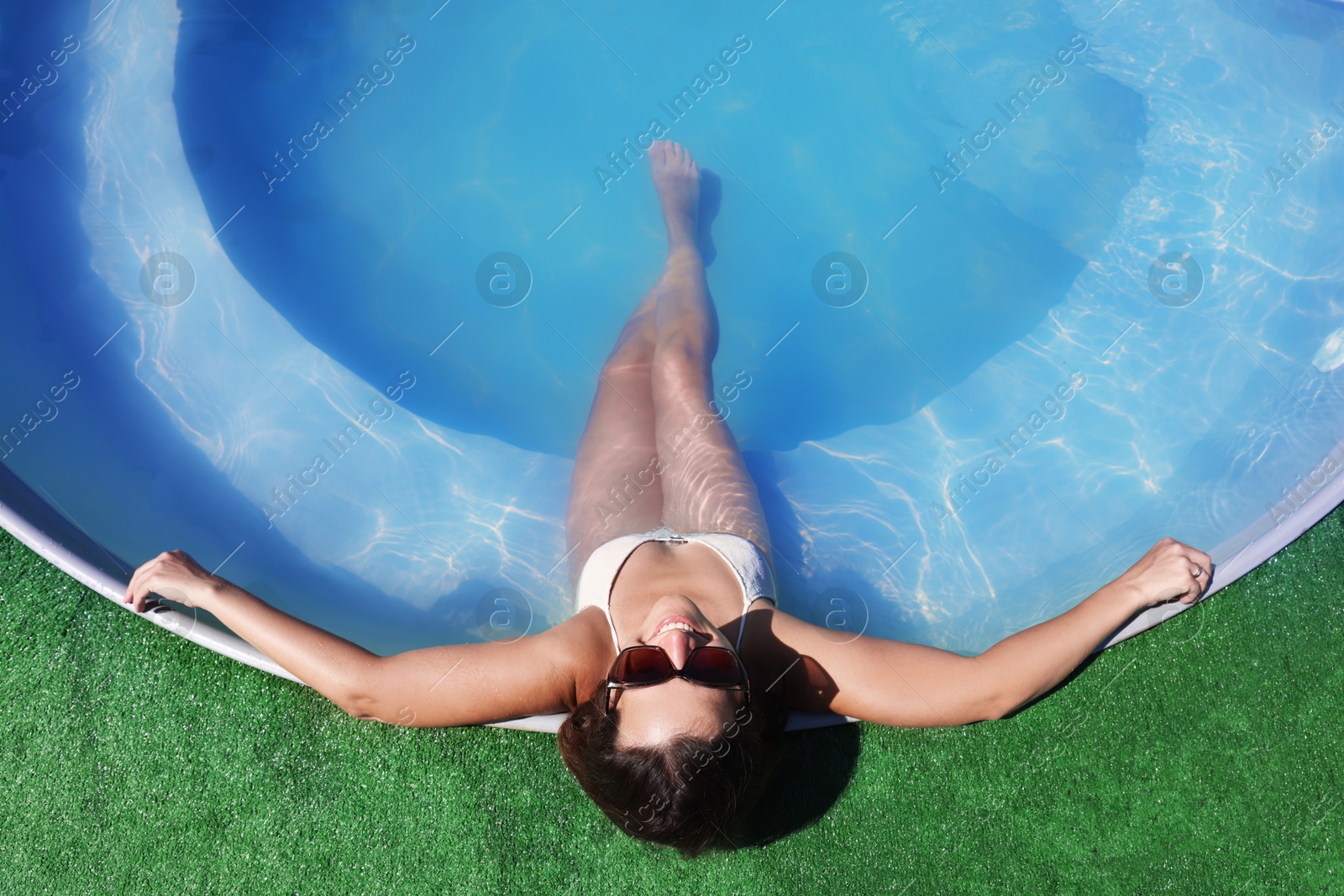 Photo of Woman relaxing in swimming pool at resort, above view