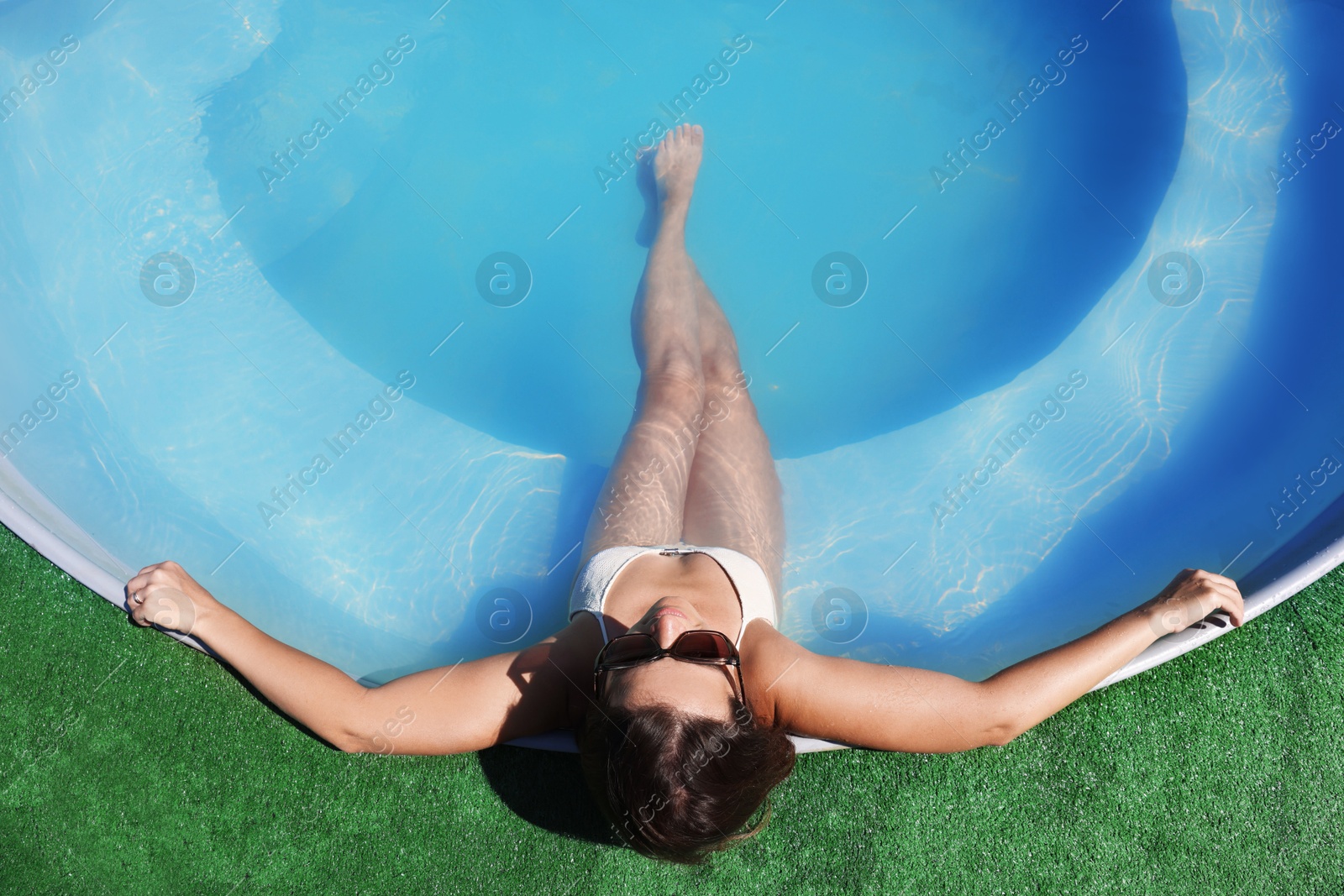 Photo of Woman relaxing in swimming pool at resort, above view