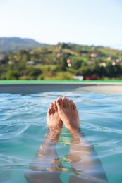 Photo of Woman relaxing in swimming pool at resort, closeup
