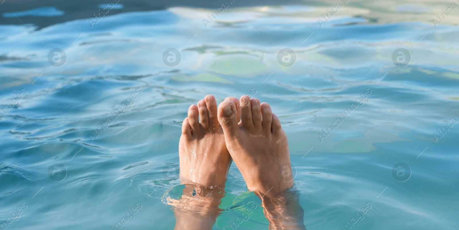 Photo of Woman relaxing in swimming pool at resort, closeup