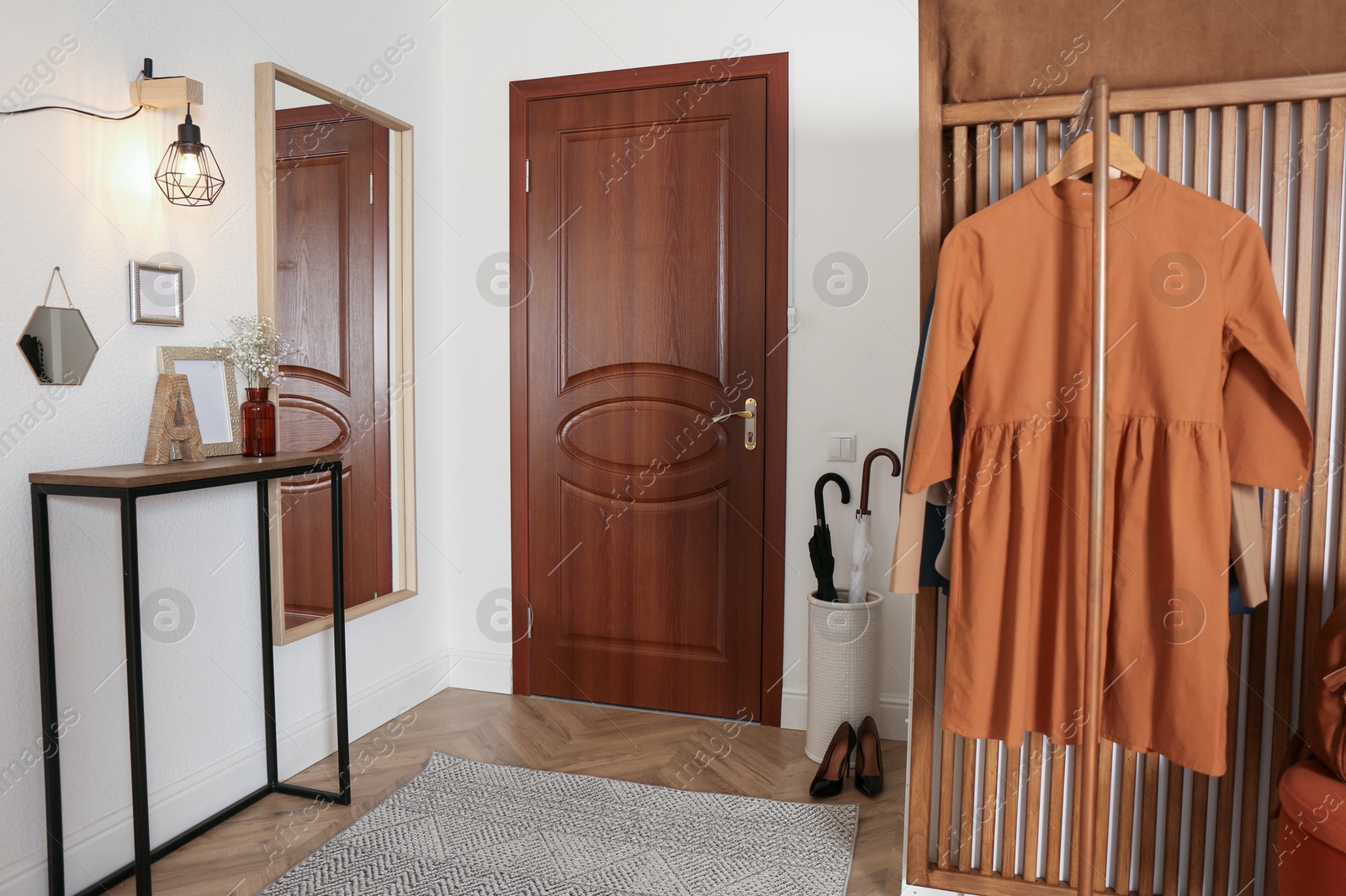 Photo of Modern hallway interior with stylish furniture and clothes rack