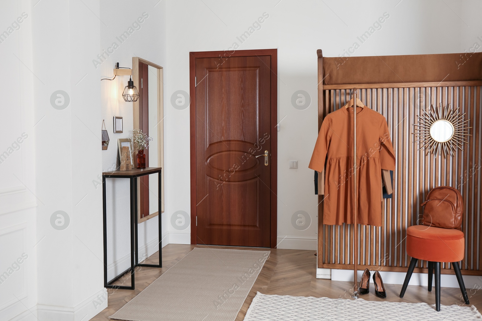 Photo of Modern hallway interior with stylish furniture and clothes rack