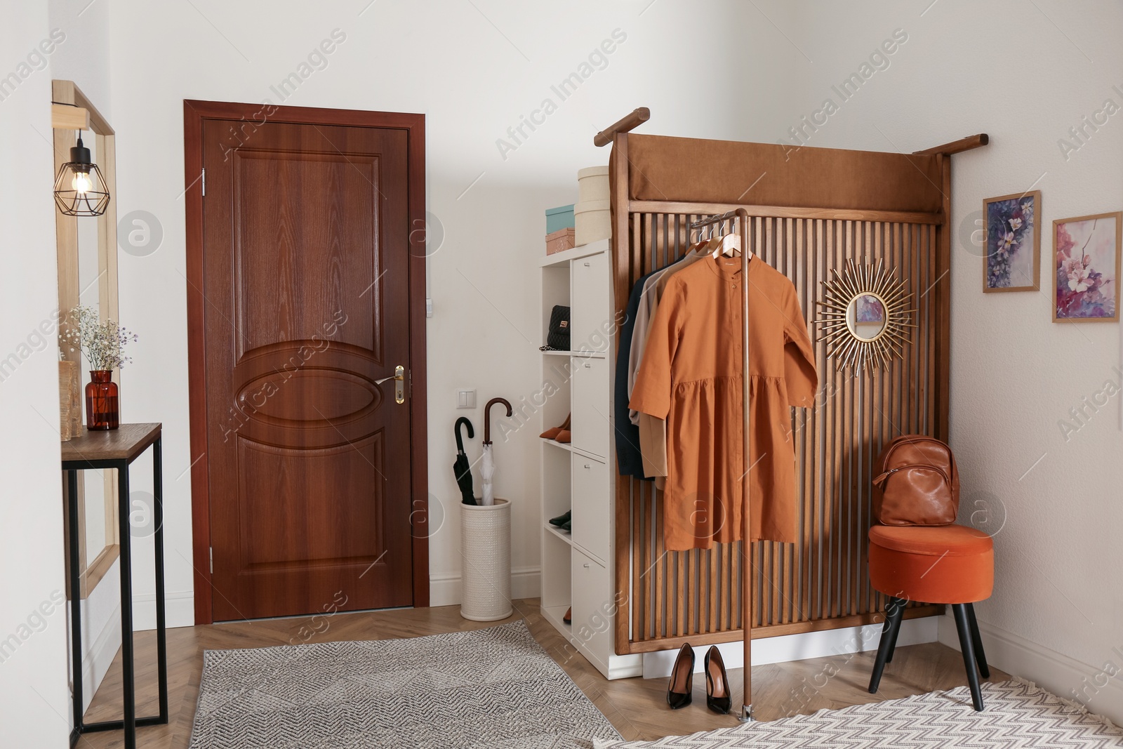 Photo of Modern hallway interior with stylish furniture and clothes rack