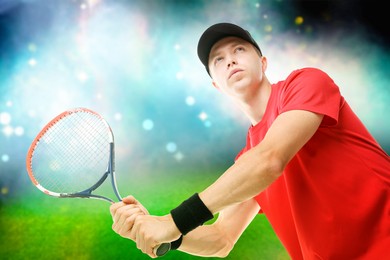 Image of Man with racket playing tennis at stadium, low angle view