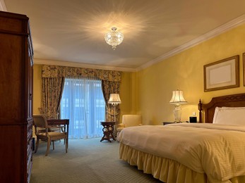 Photo of Luxury hotel interior. Comfortable large bed and modern furniture in stylish room
