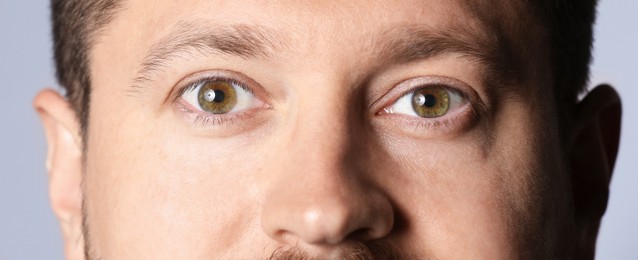 Photo of Man with beautiful eyes on light grey background, closeup