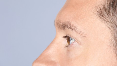 Photo of Man with beautiful eyes on light grey background, closeup. Space for text