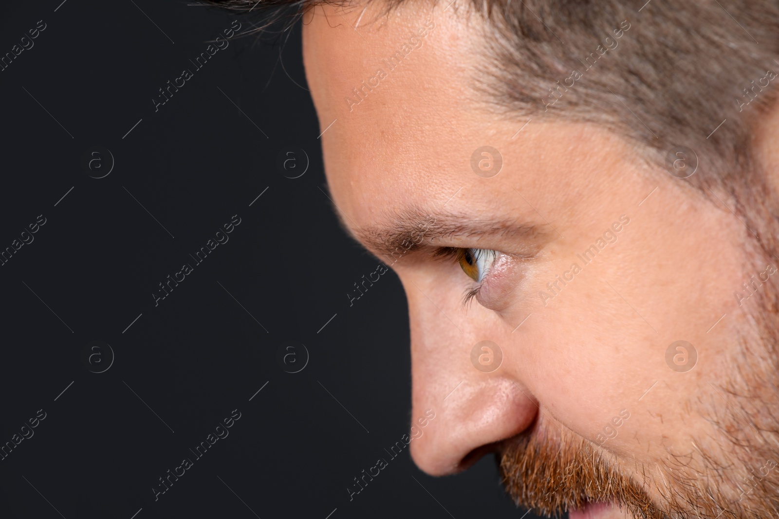Photo of Man with beautiful eyes on black background, closeup. Space for text