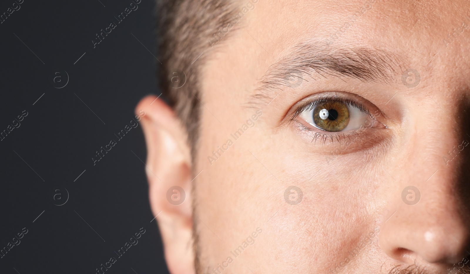 Photo of Man with beautiful eyes on black background, closeup. Space for text