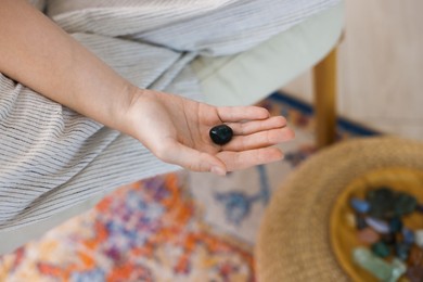 Photo of Woman with beautiful heliotrope gemstone indoors, above view