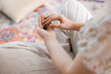 Photo of Woman with beautiful heliotrope gemstone indoors, closeup
