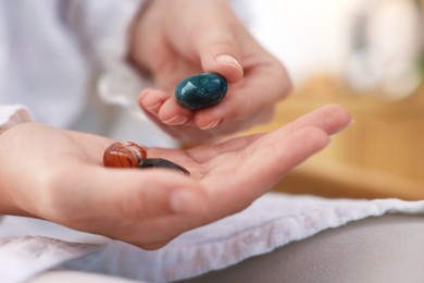 Photo of Woman with different beautiful gemstones indoors, closeup