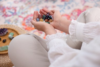 Photo of Woman with different beautiful gemstones indoors, closeup