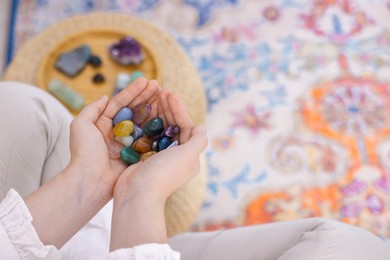 Photo of Woman with different beautiful gemstones indoors, above view. Space for text