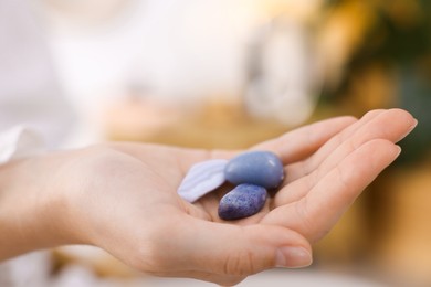 Photo of Woman with different beautiful gemstones indoors, closeup
